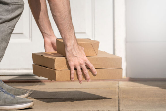 Delivery driver leaving packages at a front door, representing the growth of local online marketplaces