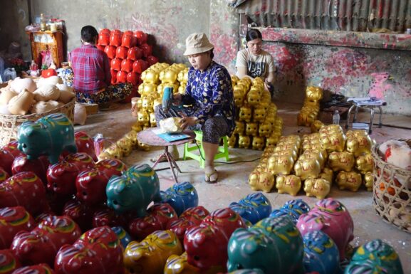 An artisan crafting colorful handmade pieces in a workshop, illustrating a beginner selling handmade goods online