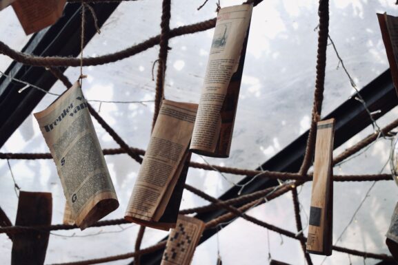 Vintage newspapers hanging on display ropes, representing the era before classified ads moved online
