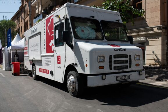 A modern food truck serving customers at a lively street festival