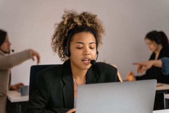 A customer support agent working on a laptop, representing help with frequently asked questions about P6D.net listings