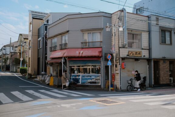 A city street intersection lined with small local shops and storefronts