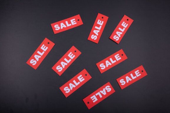 Red sale tags arranged on a dark background, representing steep discounts that may be too good to be true