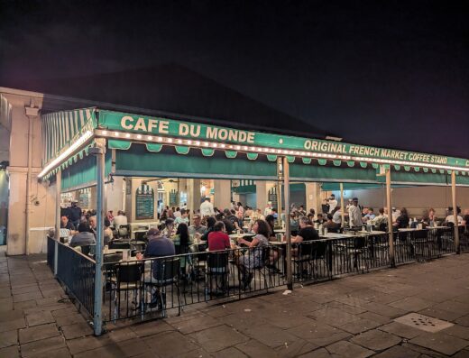 Café Du Monde coffee stand with its green-and-white awning in the French Market, New Orleans